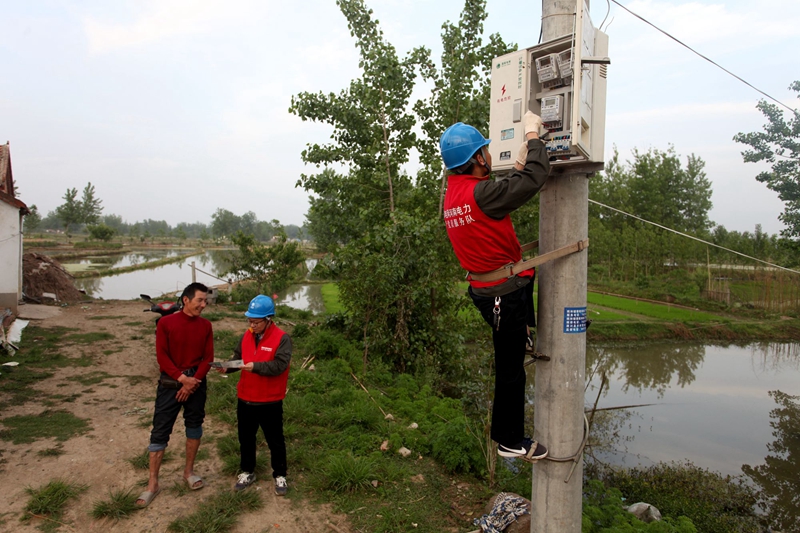 潢川县供电供电公司党员服务队队员高君、凡慧杰帮助用户张振兴安装抽水用电计量装置.jpg 潢川县供电供电公司党员服务队队员高君、凡慧杰帮助用户张振兴安装抽水用电计量装置.jpg