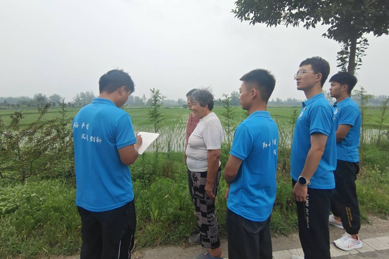 图为实践队员深入田间地头,询问农户脱贫攻坚成效.jpg